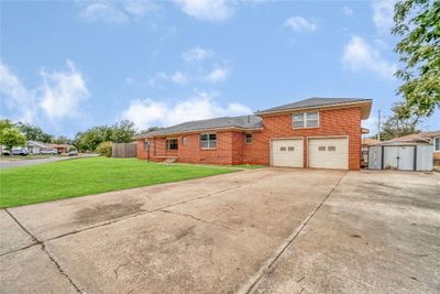 View of front of house with a storage shed, a front yard, and a garage | Image 2