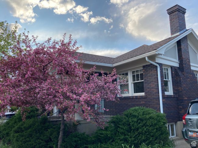 View of side of home with a chimney, a shingled roof, and brick siding | Image 33