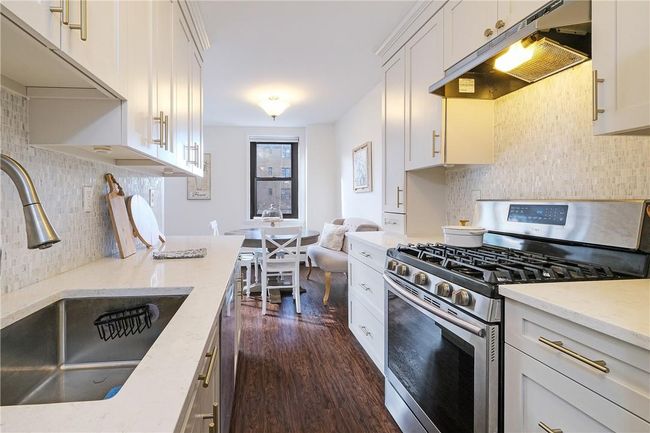 Close-up head on shot of kitchen looking toward windows. | Image 21
