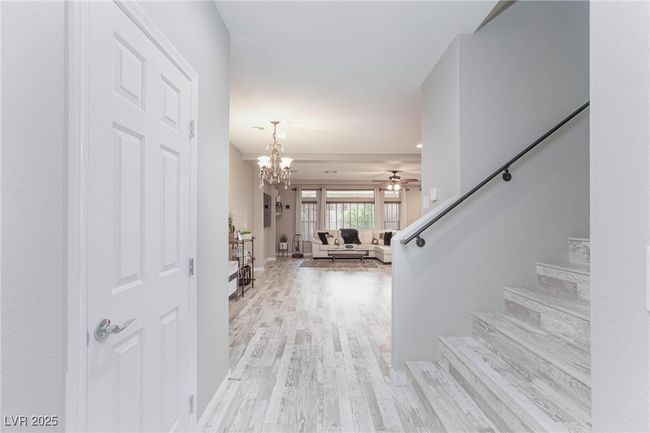 Entrance foyer featuring stairs, light wood-type flooring, and ceiling fan with notable chandelier | Image 8