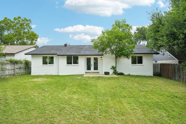 Back of house with french doors, a lawn, a fenced backyard, and brick siding | Image 21