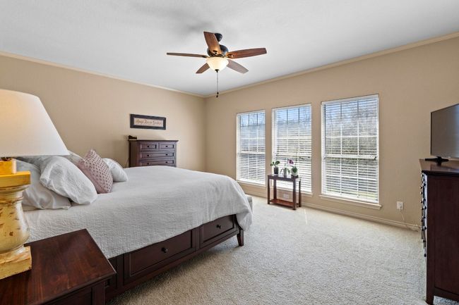 Bedroom with baseboards, light carpet, ornamental molding, and a ceiling fan | Image 20