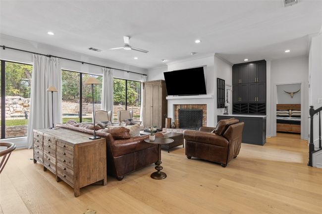 Living area featuring ceiling fan, ornamental molding, light wood finished floors, and visible vents | Image 10