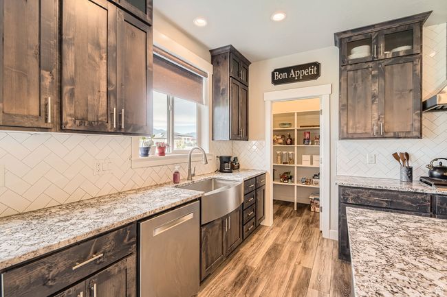 Kitchen with stainless steel dishwasher, decorative backsplash, light stone countertops, light wood-style flooring, and recessed lighting | Image 8