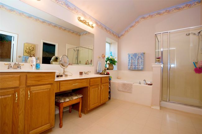Full bath featuring a shower stall, a garden tub, double vanity, and lofted ceiling | Image 17