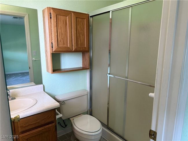 Bathroom with vanity, toilet, a shower stall, and baseboards | Image 20