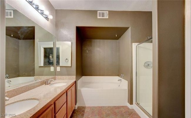 Bathroom with visible vents, a shower stall, a bath, and a sink | Image 14