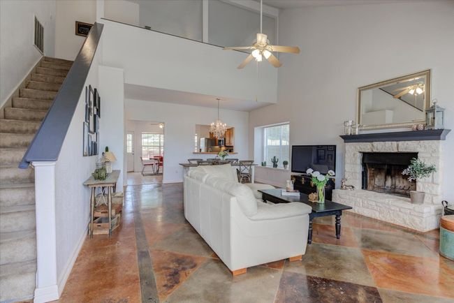 Living area features beautiful concrete floors, lovely limestone fireplace, and elegant dining space. | Image 5