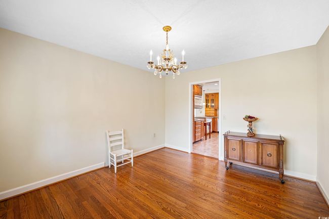 Empty room with a chandelier, wood finished floors, and baseboards | Image 29