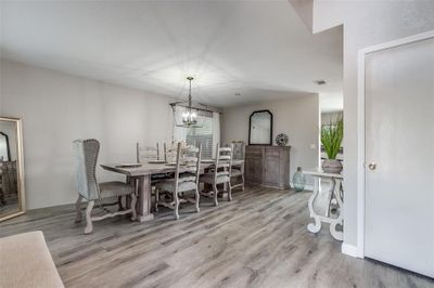 Dining area with a wealth of natural light, light hardwood / wood-style flooring, and an inviting chandelier | Image 3