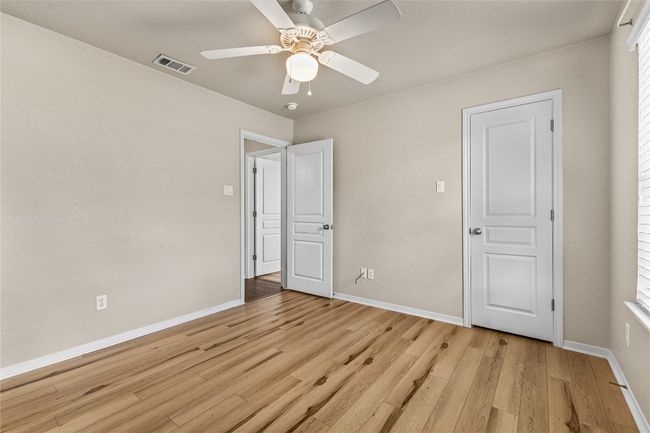 Unfurnished bedroom with light wood-type flooring, ceiling fan, and multiple windows | Image 29