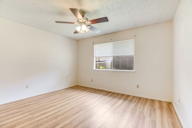 Spare room with light wood finished floors, a ceiling fan, a textured ceiling, and baseboards | Image 14