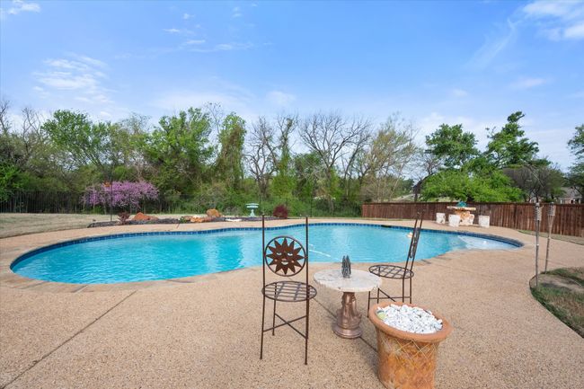 View of pool featuring blooming Wisteria and some of pool deck area. | Image 26