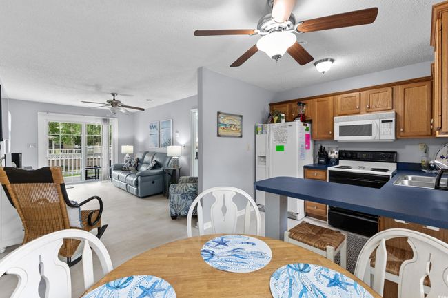 Dining room with ceiling fan, a textured ceiling, and light wood-type flooring | Image 9