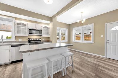 Kitchen with appliances with stainless steel finishes, sink, plenty of natural light, and white cabinets | Image 1