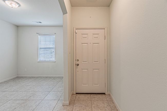 Foyer entrance featuring light tile patterned flooring and baseboards | Image 4