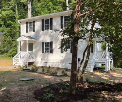 View of front of home featuring covered porches with custom railings and landscaping | Image 1