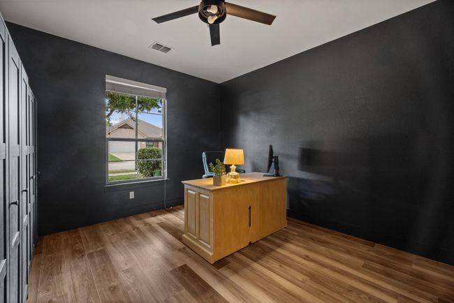 Office space featuring light wood-style floors, ceiling fan, and visible vents | Image 27