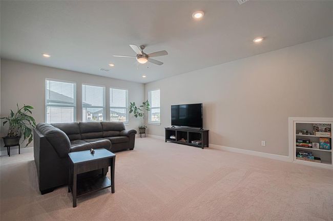 Spacious game room with neutral colors, w/built-in shelving, room for a pool table & ample natural light from multiple windows. | Image 34