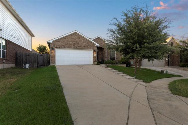 View of front of home driveway, brick siding, and a garage | Image 18