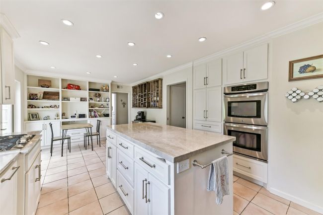 The kitchen is well-lit with recessed lighting and has built-in shelves for additional storage or decor. | Image 19