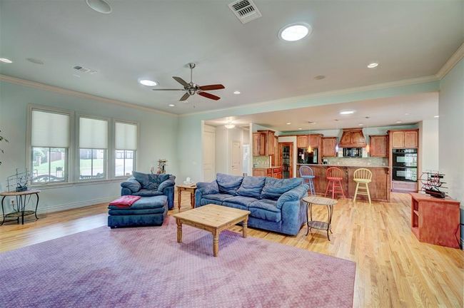 Living area featuring light wood finished floors, visible vents, and ornamental molding | Image 8