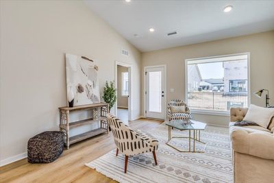 Living room with high vaulted ceiling and light wood-type flooring | Image 2