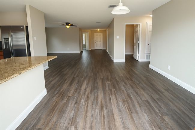 Unfurnished living room with dark wood-type flooring and a ceiling fan | Image 14