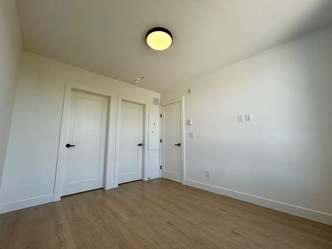 Unfurnished bedroom with light wood-type flooring and baseboards | Image 14