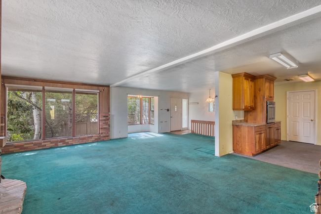 Unfurnished living room with carpet and a textured ceiling | Image 5