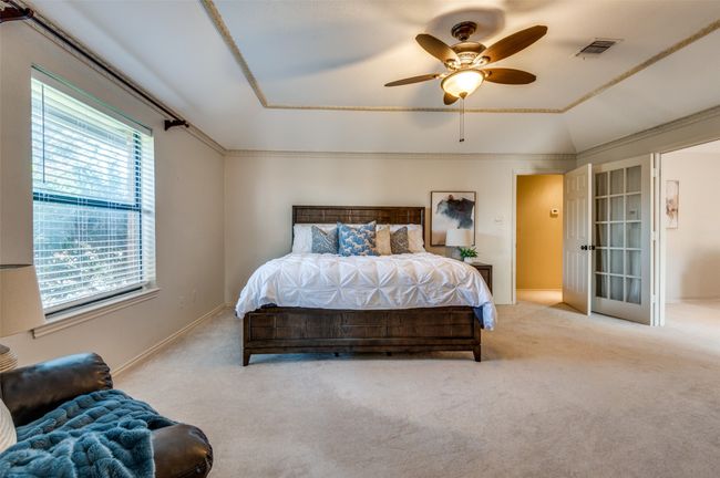 Carpeted bedroom with visible vents, vaulted ceiling, baseboards, and ceiling fan | Image 23
