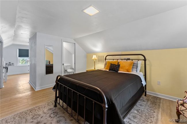 Bedroom featuring baseboards, wood finished floors, and vaulted ceiling | Image 19