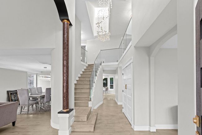 Entryway featuring baseboards, stairway, an inviting chandelier, and wood finished floors | Image 11