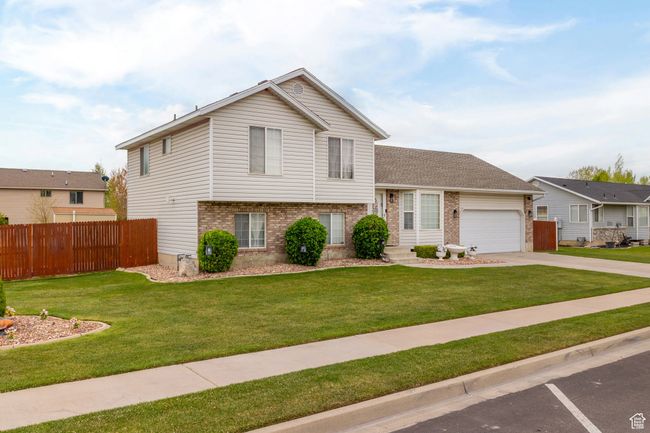 Tri-level home with a front lawn, brick siding, and fence | Image 53