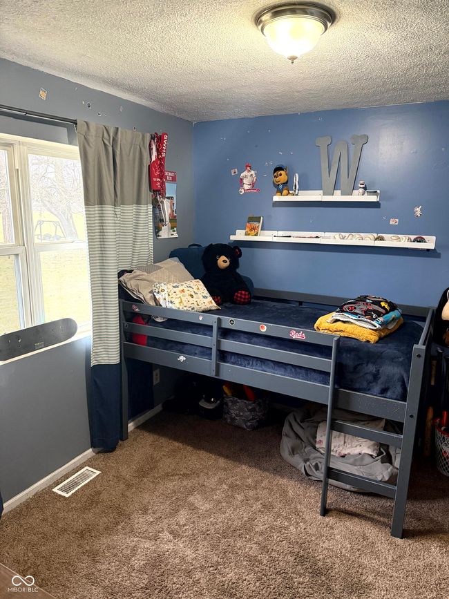 bedroom featuring a textured ceiling and carpet flooring | Image 19