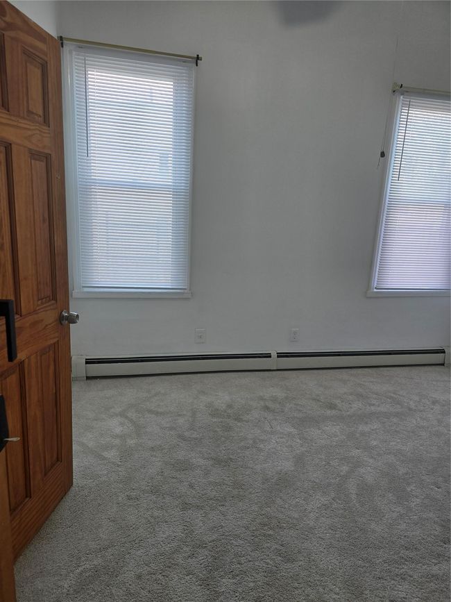 Empty room featuring carpet and baseboard heating | Image 16