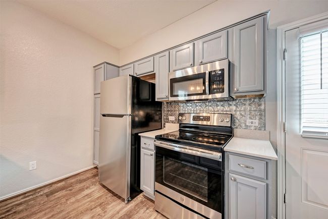 Kitchen with stainless steel appliances, gray cabinetry, and backsplash | Image 13