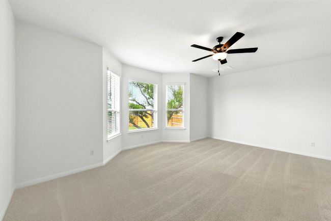 Unfurnished room featuring light colored carpet, baseboards, and ceiling fan | Image 16