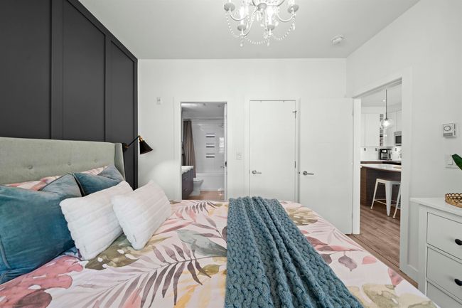 Bedroom featuring ensuite bathroom, wood finished floors, and a notable chandelier | Image 16