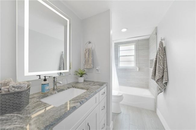 Full bathroom with vanity, toilet, and shower / bath combo with shower curtain | Image 30