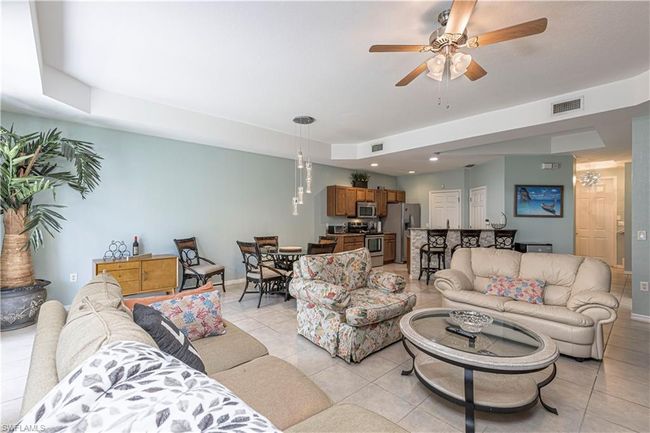 Living room featuring light tile patterned floors, visible vents, baseboards, and ceiling fan | Image 7
