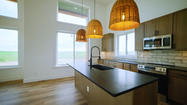 Kitchen featuring stainless steel appliances, dark countertops, a high ceiling, and healthy amount of natural light | Image 27