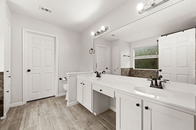 Bathroom with double vanity and wood finished floors | Image 9