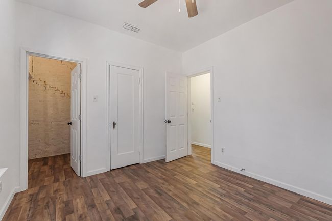Unfurnished bedroom featuring dark wood-type flooring and ceiling fan | Image 30