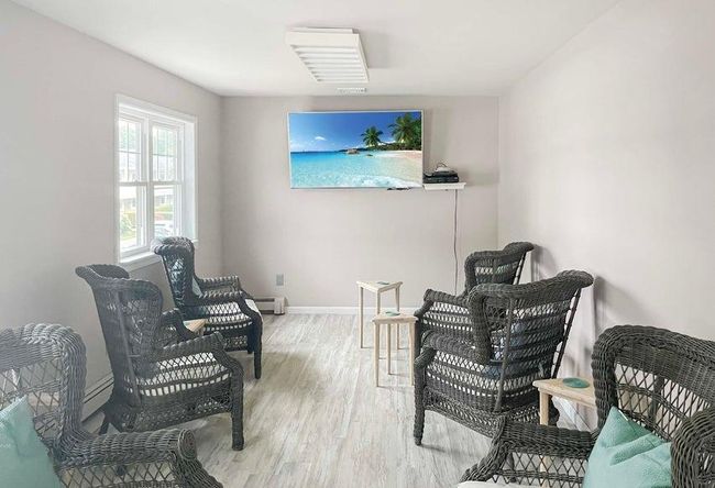 Living area with baseboards, a baseboard heating unit, and light wood finished floors | Image 14