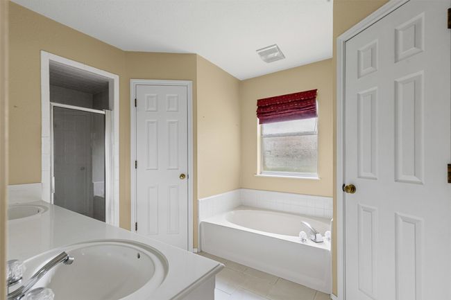 Ensuite primary bath with double vanity, a garden tub, a separate shower, and 2 walk in closets. | Image 15