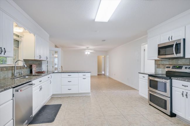 Stainless ovens, microwave and dishwasher. Granite counters and updated ample cabinets. | Image 11