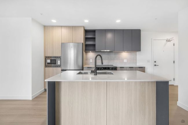 Kitchen featuring a sink, light brown cabinetry, stainless steel appliances, modern cabinets, and backsplash | Image 5