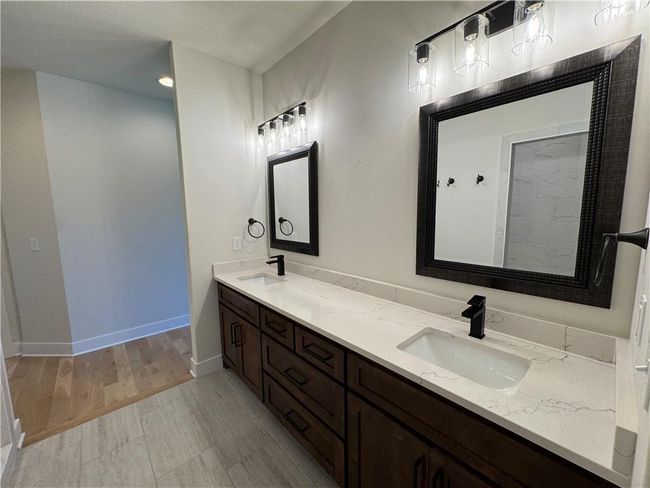 Full bathroom featuring double vanity and wood finished floors | Image 35