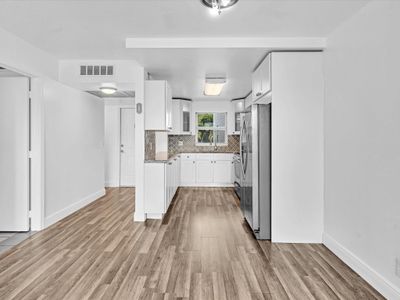 Dining Area with Bathroom entrance on left, Foyer Entrance in center, Open Kitchen on right. | Image 3